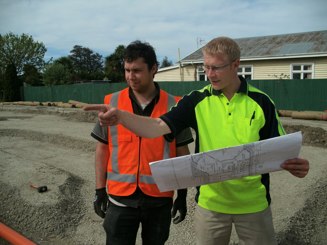 Marco from Mister Sparky and apprentice James go over site plans.