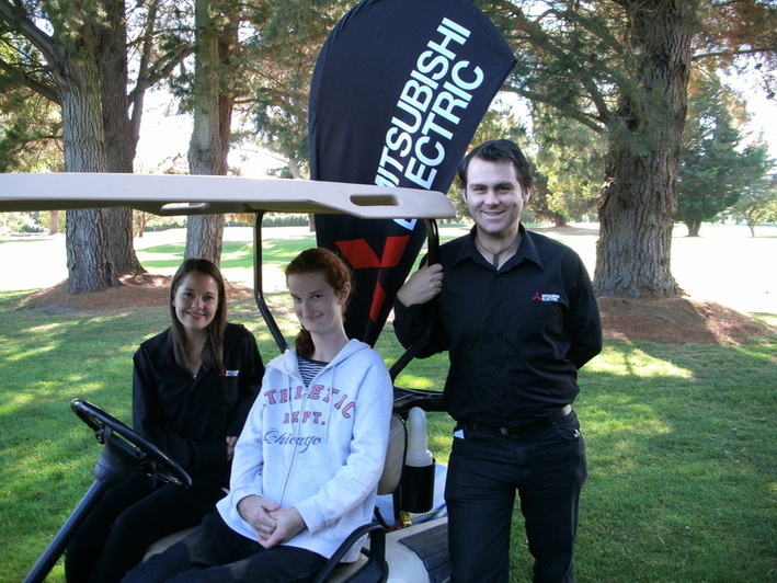 Ashley and Cameron from Heat Pumps NOW with Lilian in a golf cart at the Christchurch fundraiser.