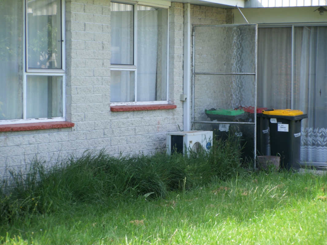 A heat pump at an abandoned house covered with grass. How efficient do you think it will be?
